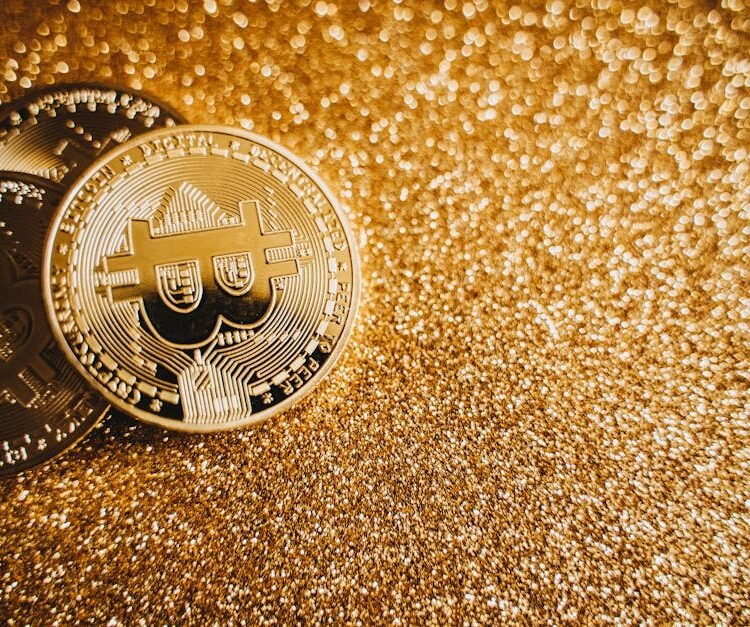 Close-up of bitcoins on a shimmering gold background, symbolizing digital wealth and investment.